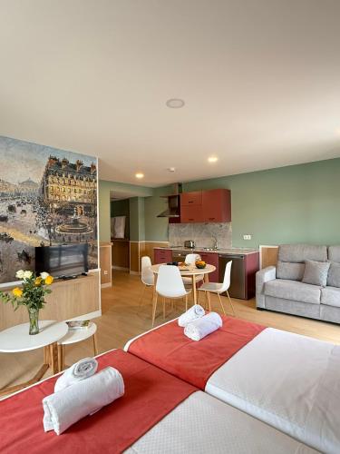 a room with two beds and a living room and a kitchen at Luxury Singular Pensión Estudios Blue in Santiago de Compostela