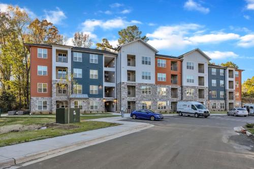 an apartment complex with cars parked in a parking lot at Luxe King 3BR Suite Mins to Downtown Durham in Durham