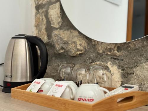 a wooden tray with cups and a tea kettle and glasses at Te Gjyshi in Berat