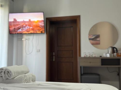 a bedroom with a bed with a tv on the wall at Te Gjyshi in Berat