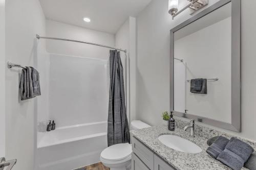 ダーラムにあるLuxe King 3BR Suite Mins to Downtown Durhamの洗面台と鏡のある白いバスルーム