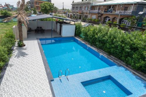 an overhead view of a swimming pool with blue water at CASA Resort and Restaurant in Rāmnagar