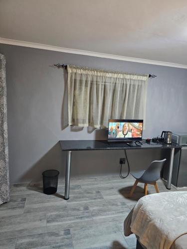 a desk with a computer on it in a bedroom at Lanico in Witbank