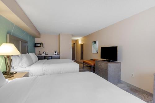 a hotel room with two beds and a flat screen tv at Comfort Inn & Suites Boulder in Boulder