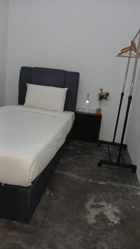 a bedroom with a bed and a desk with a lamp at Hotel Lang Hoose in George Town