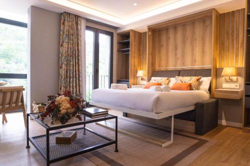 a bedroom with a large bed and a table at Loureira in Pincelo