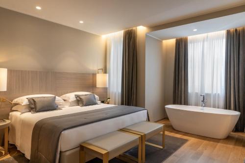 a bedroom with a large bed and a bath tub at Rosa Grand Milano - Starhotels Collezione in Milan