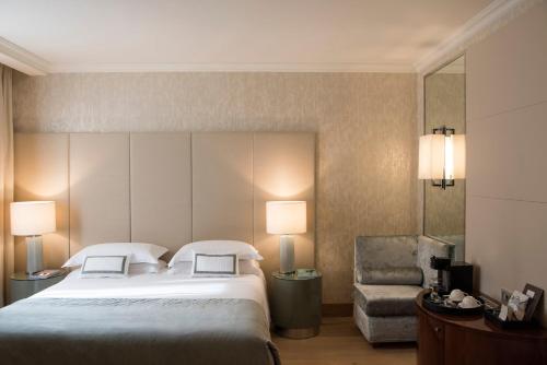 a hotel room with a large bed and a chair at Rosa Grand Milano - Starhotels Collezione in Milan