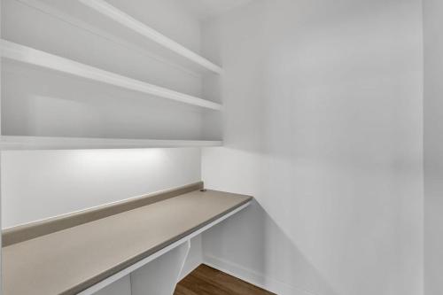 a white walk in closet with white shelves at Upscale King 3BR Suite Mins to Downtown Raleigh in Cary
