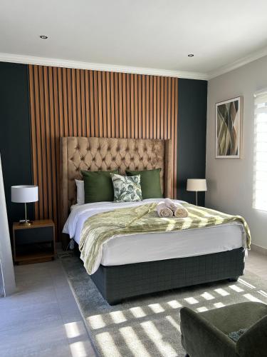 a bedroom with a large bed and a striped wall at Bontle R Guesthouse in Parys