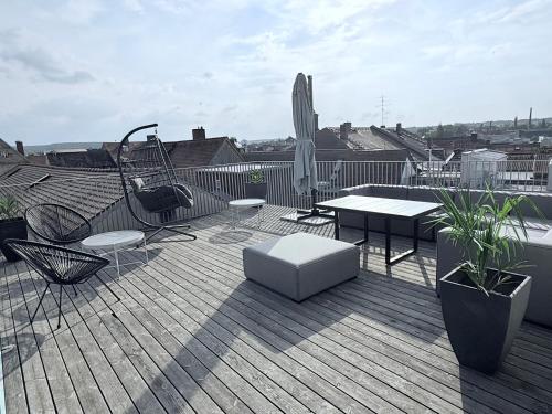 a deck with a table and chairs and a swing at designAparts - I - Penthouse mit Dachterrasse in Bayreuth