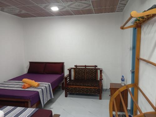 a room with two beds and a chair in it at Wilpattu Buma Lodge in Pahala Maragahawewa