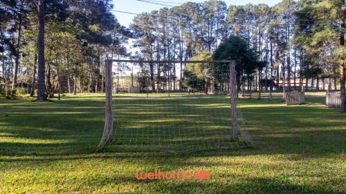 a net in the middle of a field with trees at Sitio em Sarapui com piscina e lareira in Sarapuí