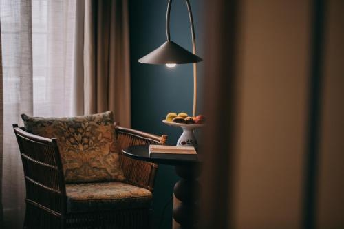 a room with a table and a chair and a lamp at Torel Terra Brava in Angra do Heroísmo