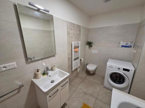 a bathroom with a sink and a washing machine at Apartmán RETRO in Žilina