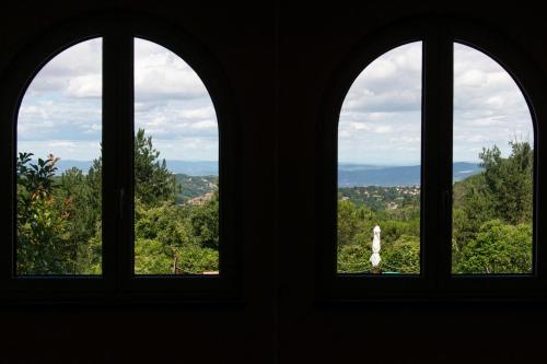 three windows in a building looking out at a city at Toscana Wellness Resort in Arcidosso