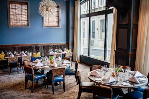 a dining room with tables and chairs and windows at The Virginian Lynchburg, Curio Collection By Hilton in Lynchburg