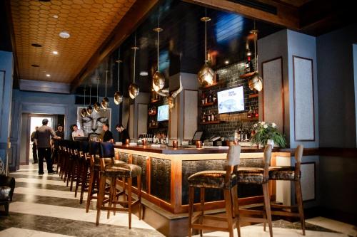 a bar in a restaurant with a bunch of chairs at The Virginian Lynchburg, Curio Collection By Hilton in Lynchburg