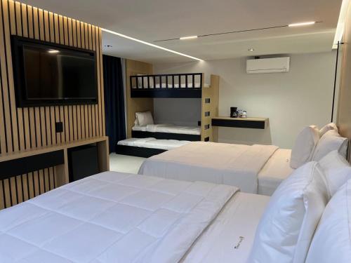 a hotel room with two beds and a flat screen tv at Hotel Lepanto Reforma in Mexico City