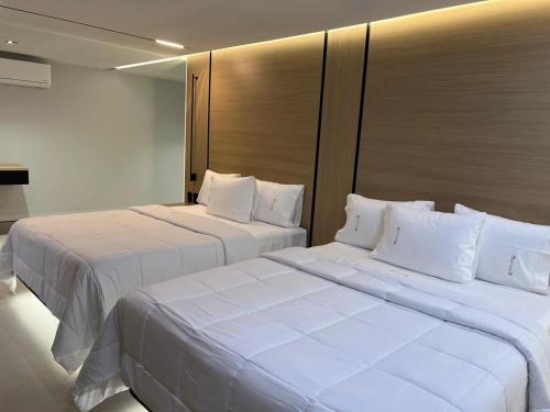 two beds in a hotel room with white pillows at Hotel Lepanto Reforma in Mexico City