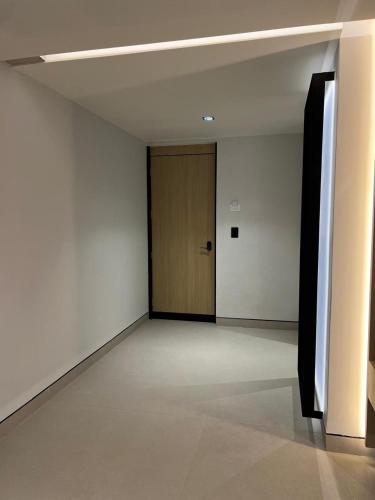 a hallway with a door in a room with white walls at Hotel Lepanto Reforma in Mexico City