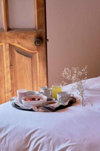 a breakfast tray with cups and plates of food on a bed at Maimara Hotel in Huaraz