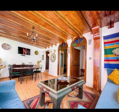 étage 2 avec terrasse vue sur mer في الجديدة: غرفة معيشة مع أريكة زرقاء وطاولة