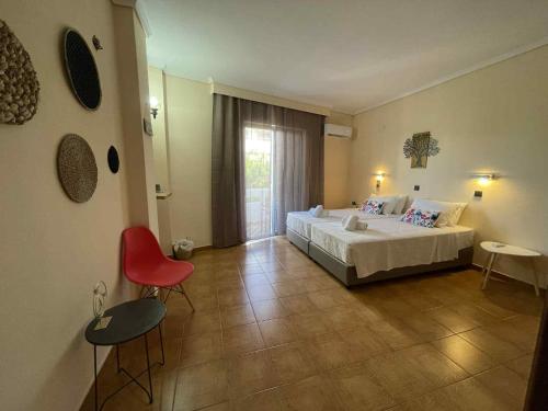 a bedroom with a bed and a red chair at COSY Urban Living in Kos Town