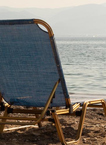 a beach chair sitting on the beach next to the water at Tropical Beach "Nereus" in Petalidhion