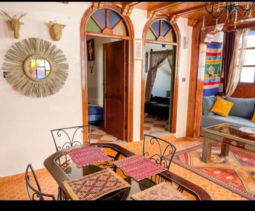 étage 2 avec terrasse vue sur mer في الجديدة: غرفة معيشة مع طاولة وكراسي وأريكة