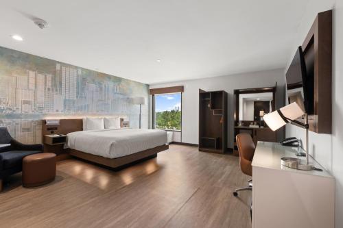 a hotel room with a bed and a desk and chair at Cambria Hotel Orlando near Universal Theme Parks in Orlando
