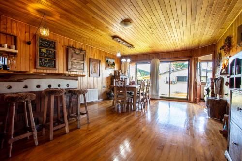 a large room with a bar and a table and chairs at Hostal Boutique El Vergel Azul in Castro