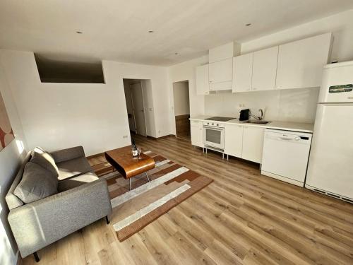 a living room with a couch and a kitchen at Peaceful Poolside Studio 20min from BCN in Sant Cugat del Vallès