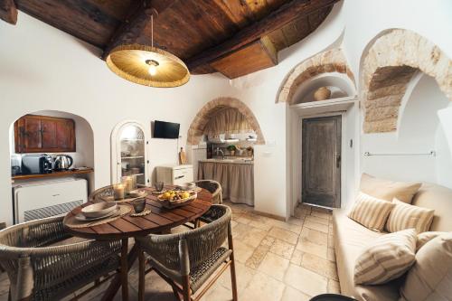 a kitchen and living room with a table and chairs at Trullo Anteros in Alberobello