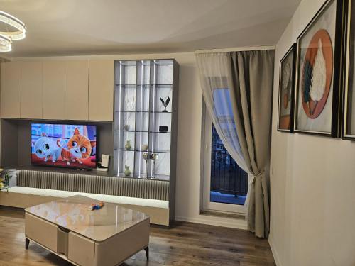 a living room with a tv and two windows at Apartament Rosenau in Râşnov