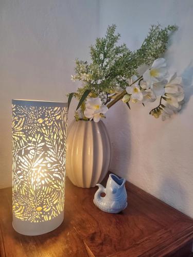 two vases sitting on a wooden table with flowers in them at Acera del Duende-Sardina in Gáldar