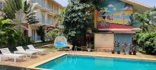 a hotel with a swimming pool in front of a building at Passions de Goa in Anjuna