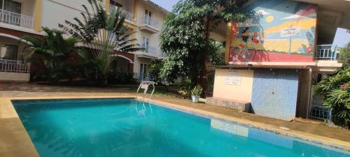 a swimming pool in front of a building at Passions de Goa in Anjuna