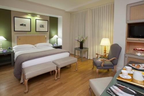a hotel room with a large bed and a chair at Starhotels Tuscany in Florence