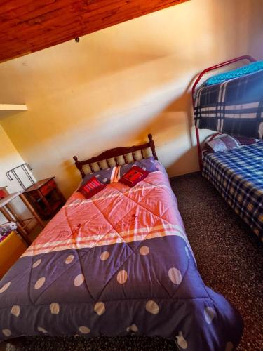 a bedroom with a bed with a colorful comforter at Hostal 'La Cholita María' in Humahuaca