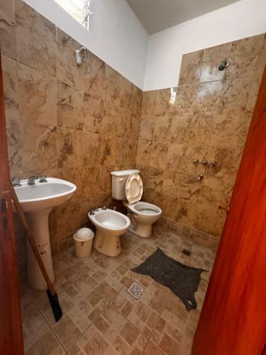 a bathroom with a toilet and a sink at Hostal 'La Cholita María' in Humahuaca