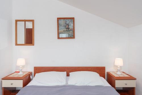 a bedroom with a bed with two night stands and two lamps at Apartments Darko in Vir