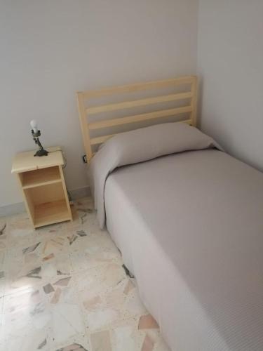 a small bedroom with a bed and a night stand at La Casa di Carola in San Fratello