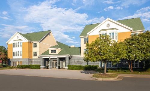 a large building with yellow and green roofs at Homewood Suites by Hilton Dulles-North Loudoun in Ashburn