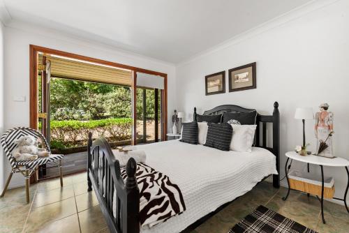 贝利Berry Beach Holiday Cottage的一间卧室设有斑马图案床和窗户