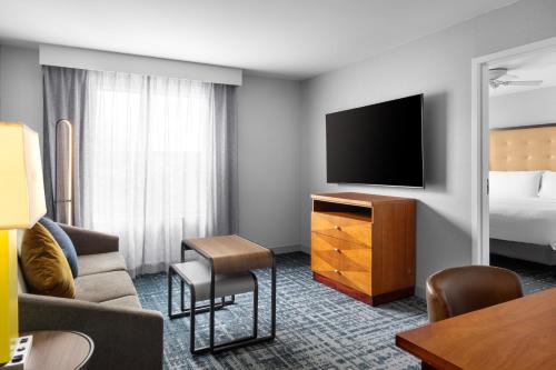 a hotel room with a bed and a flat screen tv at Homewood Suites by Hilton Dulles-North Loudoun in Ashburn