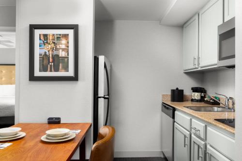 a kitchen with a wooden table and a refrigerator at Homewood Suites by Hilton Dulles-North Loudoun in Ashburn