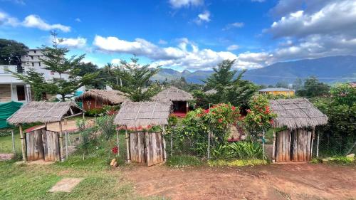 a group of wooden huts with flowers on them at Mannora Resorts Marayoor in Maraiyūr
