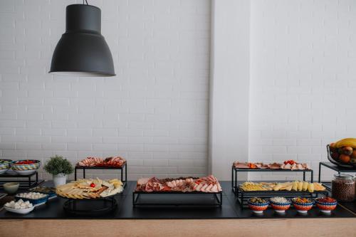 a table with several trays of different types of food at Hotel Matija Gubec in Stubicke Toplice