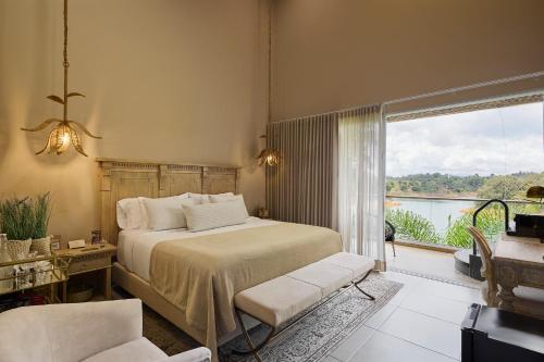 a bedroom with a bed and a large window at Tau House in Guatapé